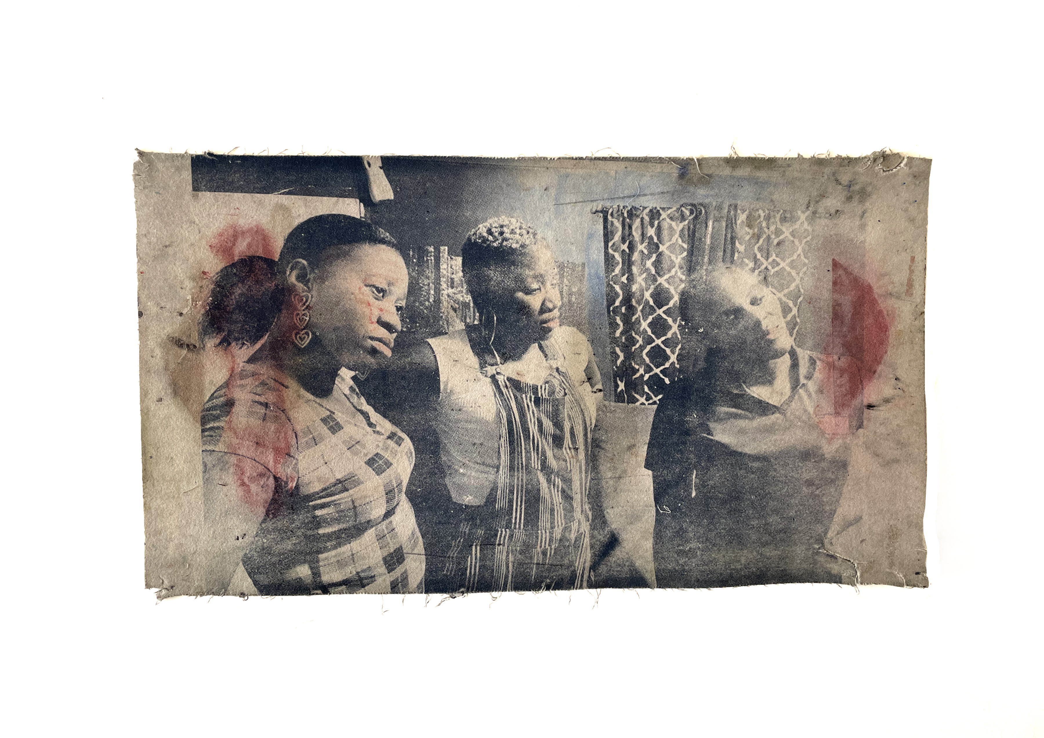 Faded black and white photograph of four Black women in an interior space, overlaid with translucent red and pink gestural marks. The photograph is aged and weathered with visible creasing and discoloration, mounted on a light background.
