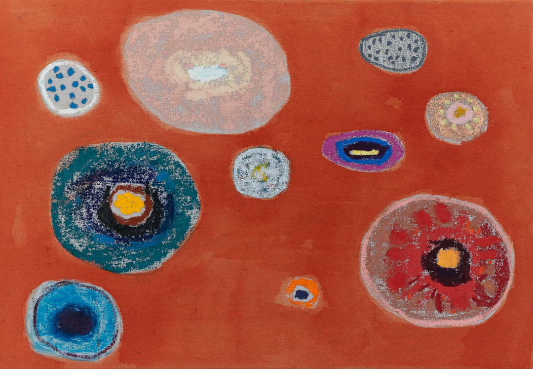 A vibrant red-orange canvas populated with concentric circular forms in varying sizes, rendered in blues, teals, whites, pinks, and earth tones. Each circle contains layered rings with contrasting colors and textured surfaces, creating an organic, cellular appearance against the warm monochromatic background.