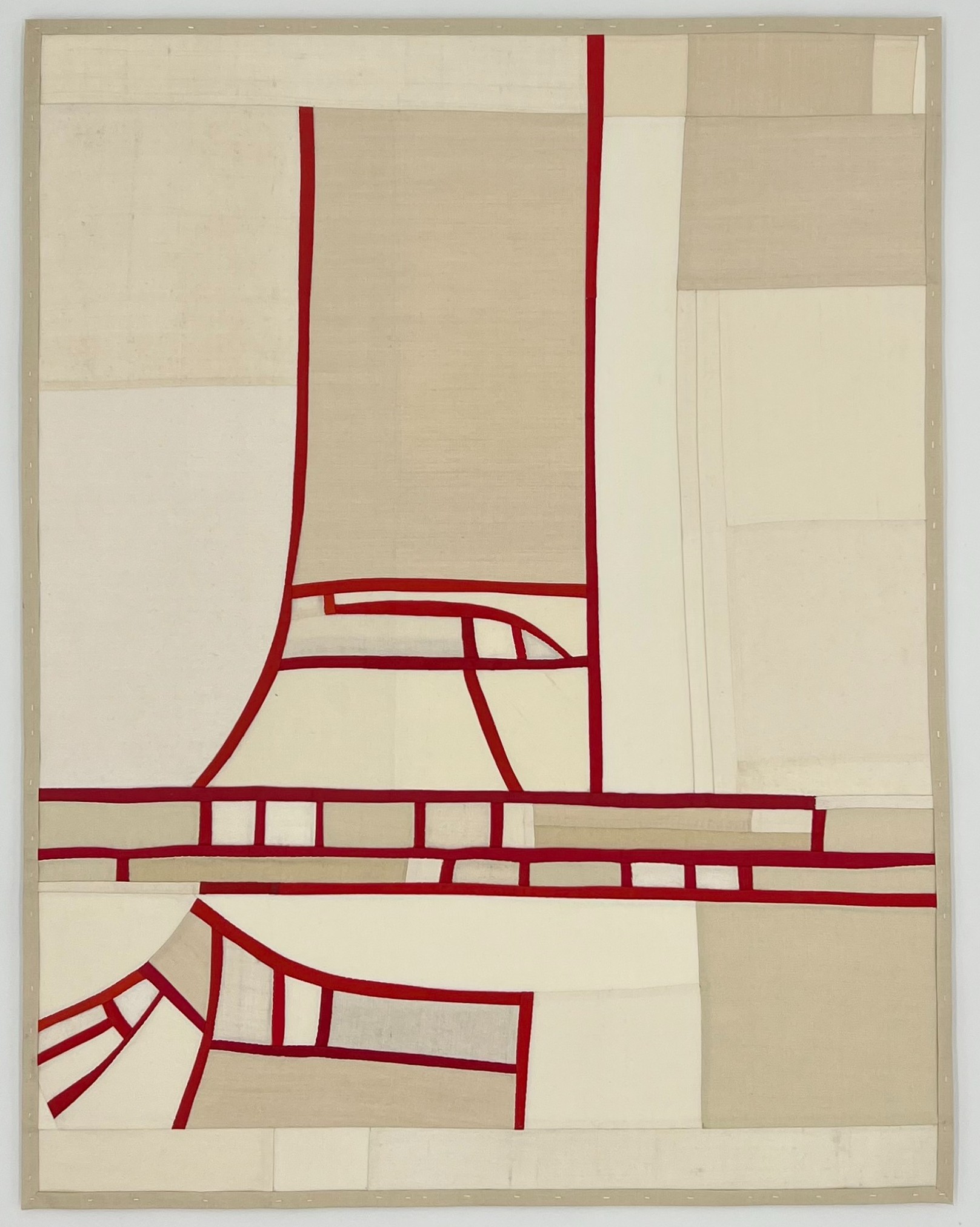 Abstracted architectural form rendered in deep red lines on a patchwork background of cream and tan fabric pieces. The composition depicts stacked horizontal and vertical elements suggesting a building or structure, composed from strips and rectangles of vintage silk in muted, neutral tones.