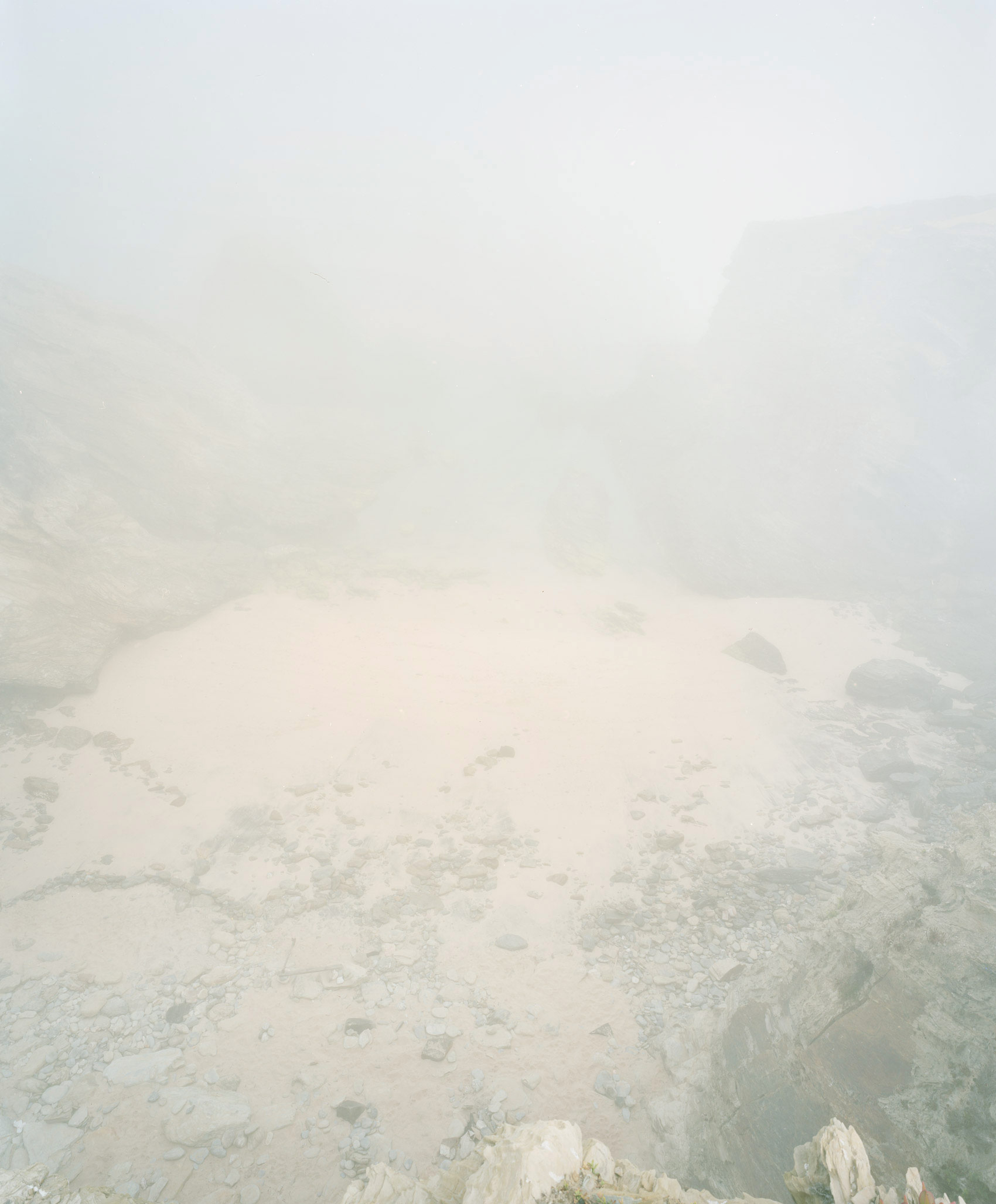 Hazy aerial view of a geothermal landscape with steaming vents and mineral-deposited terrain, rendered in soft whites and grays with minimal visibility through dense vapor and mist.