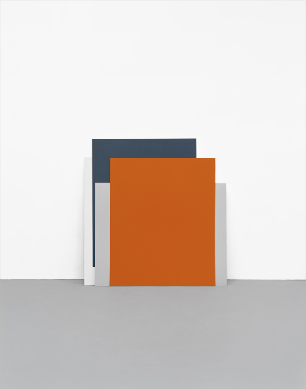 Abstract geometric composition featuring overlapping rectangular forms in dark gray, orange, and light gray tones arranged against a gray ground, creating a minimalist architectural or sculptural arrangement.