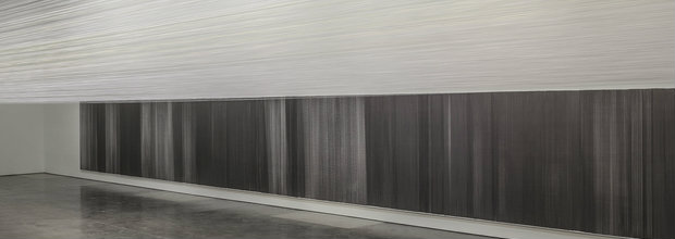 A minimalist gallery installation featuring a horizontal division of space: delicate white threads suspended at eye level creating an ethereal cloud-like form across the upper portion, contrasted below by a dense, dark striped drawing that spans the length of the wall, with polished concrete flooring reflecting the composition.